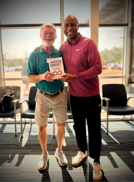 Dr. Samuel Jones with a reader holding a copy of Momentum Mindset®