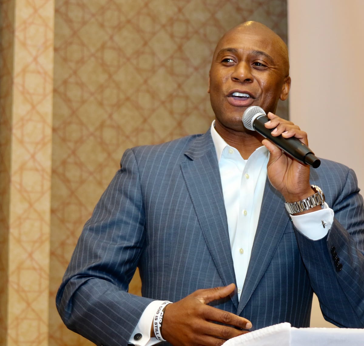 Dr. Samuel Jones speaking into a handheld microphone